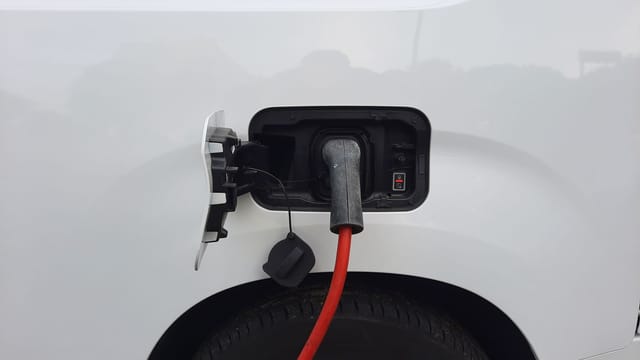 Close-up view of an electric vehicle charging port with a connected charging cable.