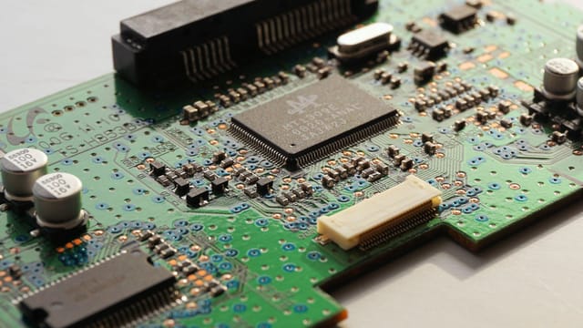 Detailed close-up photo of a circuit board highlighting microchip components and electronic circuits.