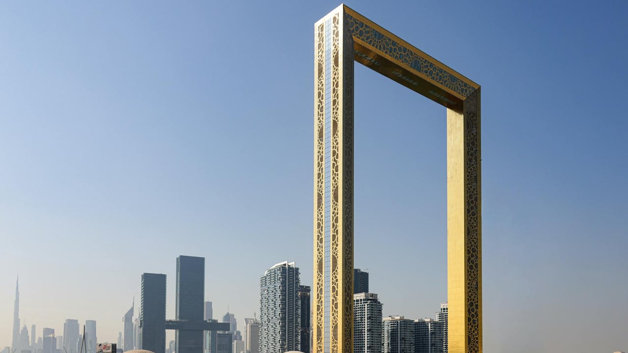 The iconic Dubai Frame with city skyscrapers in the background under a clear sky.