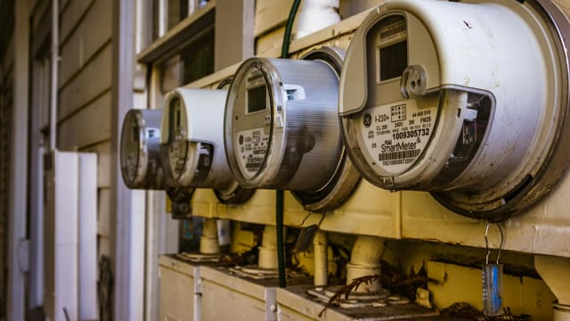 Image of multiple smart electricity meters installed on a residential exterior wall, showing environmental adaptation.