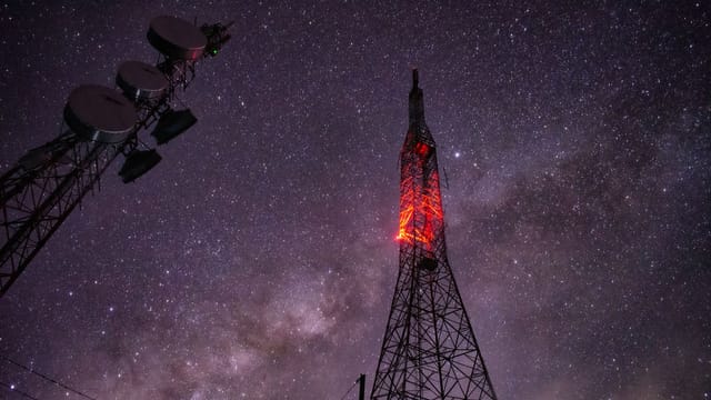 Stunning capture of a communication tower under a star-filled night sky.