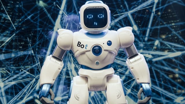A modern humanoid robot with luminous features set against a digital network backdrop.