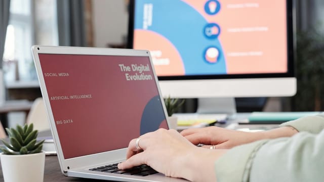 Laptop user typing with digital evolution concept on screen in a modern office environment.