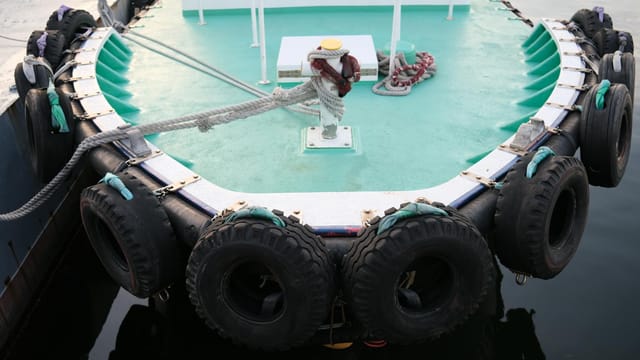 Close-up of a boat with tire fenders moored in Yokohama, Japan.