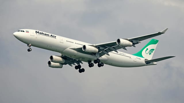 Mahan Air Airbus A340 captured mid-flight against a cloudy sky, showcasing aviation dynamics.