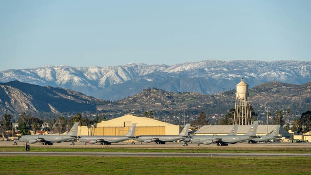 U.S. Air Force planes stationed at March Air Reserve Base with snow-capped mountains in the background.
