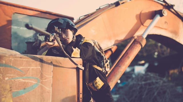Sniper in tactical gear aiming during urban warfare simulation. Perfect for military concepts.