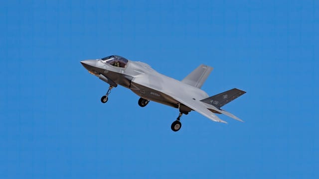An F-35 fighter jet soaring through a bright blue sky in Los Llanos, Spain.