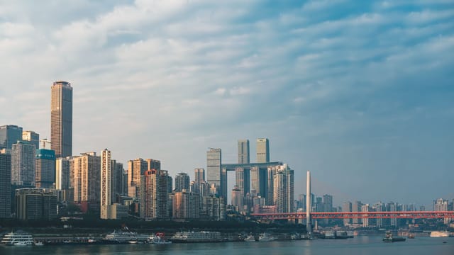 Panoramic view of Chongqing skyline with Yangtze River and urban architecture.
