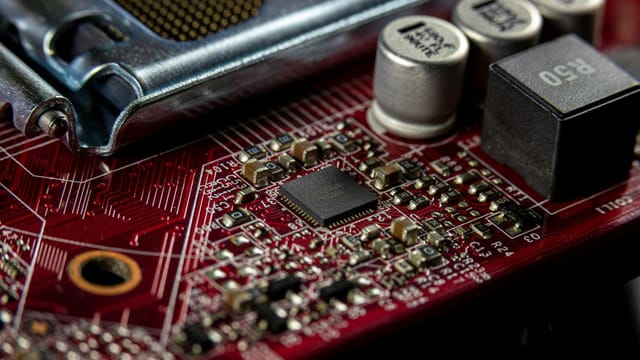 Detailed macro shot of a computer motherboard showcasing capacitors, chips, and circuits.