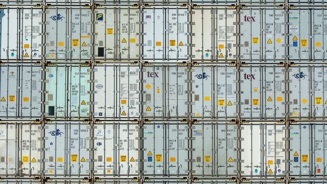 A patterned array of industrial shipping containers stacked in a storage terminal.