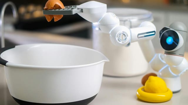 A robotic helper cracks an egg into a bowl in a contemporary kitchen setting, showcasing automation in cooking.