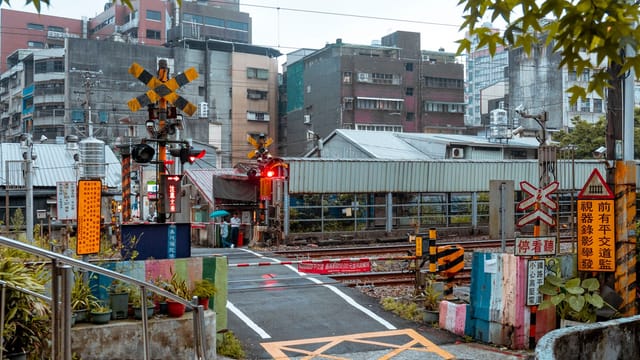 City street view of a railway level crossing in Taiwan, vibrant and bustling.