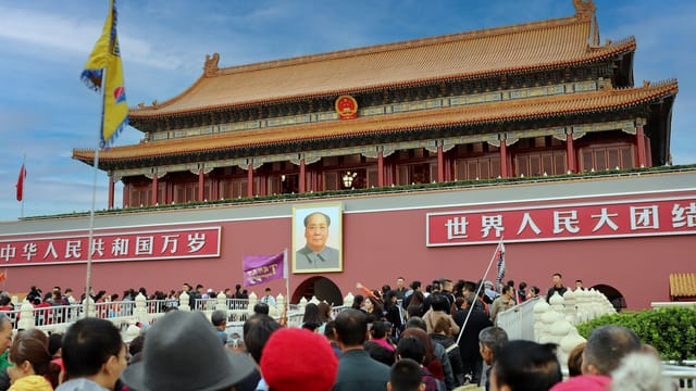 A large crowd gathers at the historic Tiananmen Gate in Beijing, China, showcasing Chinese architecture and culture.