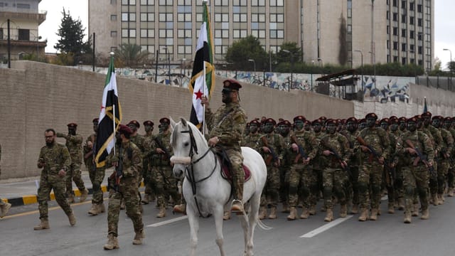 Syrian army soldiers in a parade in Damascus, showcasing unity and national pride.