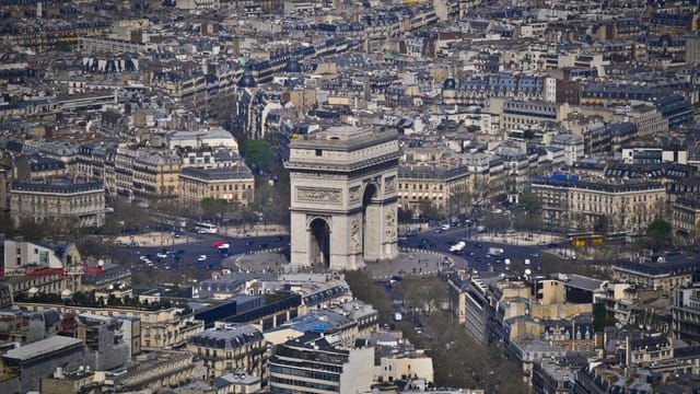 Stunning aerial shot of the Arc de Triomphe surrounded by Parisian architecture.