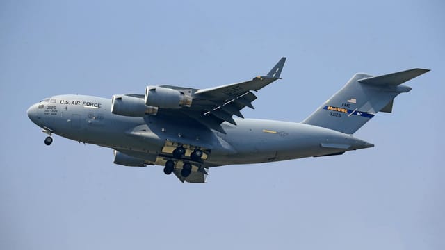 Boeing C-17 Globemaster III of the US Air Force flying in a clear blue sky.