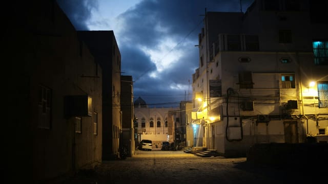 Peaceful evening street scene in Tarim, showing traditional architecture under a cloudy sky.