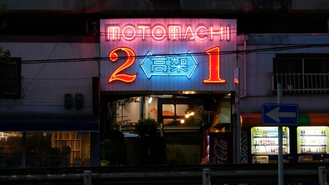 Neon-lit entrance in Kobe, Japan, showcasing vibrant street ambiance at night.