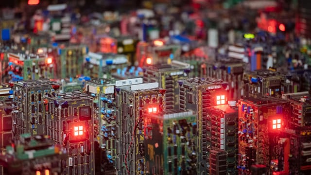 Close-up view of illuminated circuit boards resembling a cityscape, showcasing intricate electronic design.