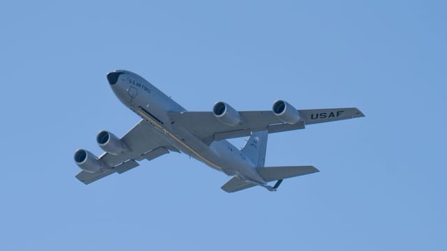 A US Air Force aircraft flying against a clear blue sky, showcasing aviation power.