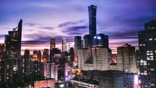 Explore the vibrant skyline of Beijing as twilight paints the horizon in this stunning aerial shot.