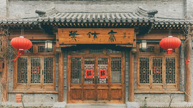 Front view of a traditional Chinese building decorated with red lanterns and wooden doors.