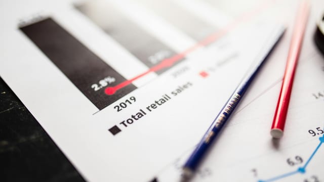 Detail view of retail sales chart and pencils on desk, showcasing data analysis.