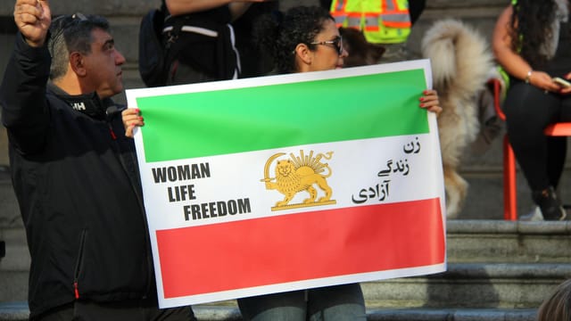 People holding signs for the Woman Life Freedom protest in Vancouver, Canada.