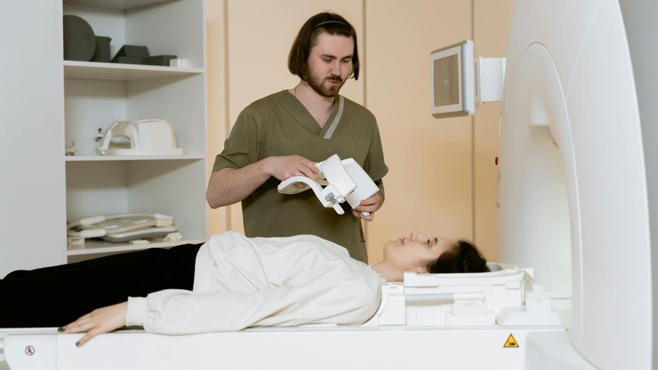 Healthcare worker assisting a patient during an MRI scan in a medical facility.