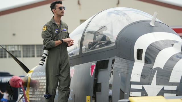 A military pilot standing on a fighter jet during an air show in Hampton, Virginia.
