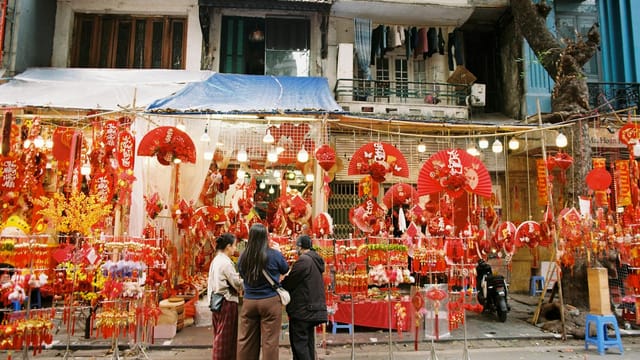 Vibrant street market in Vietnam with festive red decorations for Lunar New Year.