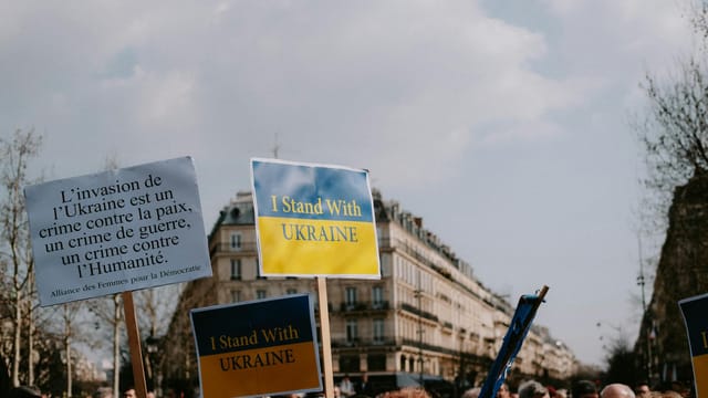 Protesters rally in the city holding signs supporting Ukraine and denouncing invasion.