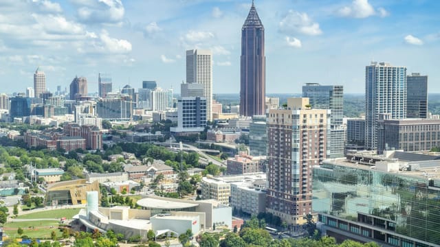 A breathtaking aerial view of the Atlanta skyline with high-rise buildings under a clear blue sky.