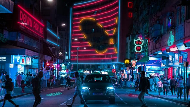 A bustling night street scene in Hong Kong with neon lights and pedestrians crossing.