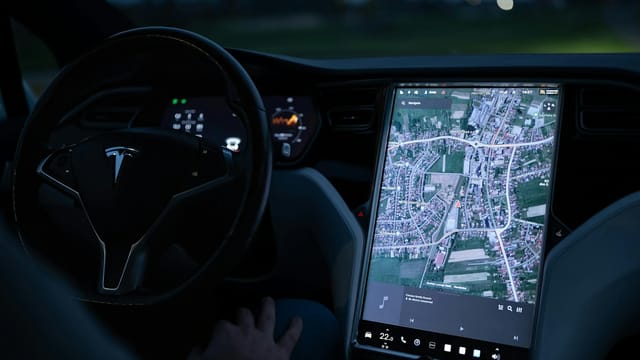 Explore the advanced touchscreen navigation in a modern electric vehicle's sleek interior at night.