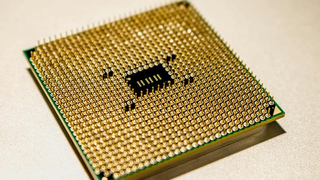 Detailed close-up of a golden microprocessor chip, ideal for technology concepts.