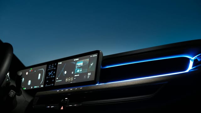 High-tech car dashboard featuring navigation and entertainment screens illuminated at night.