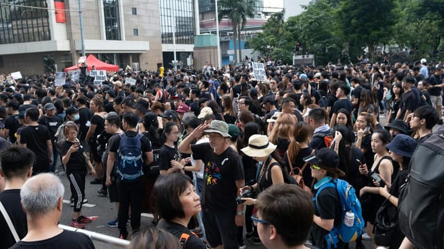 Crowds gather for a peaceful protest in the urban streets of Hong Kong, advocating for justice and freedom.