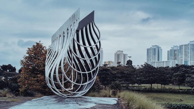 Abstract sculpture in urban park in Singapore with city skyline backdrop. Perfect for travel and architecture themes.