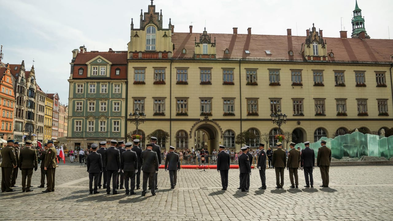 A military ceremony in Wroclaw's Market Square with soldiers standing in formation.