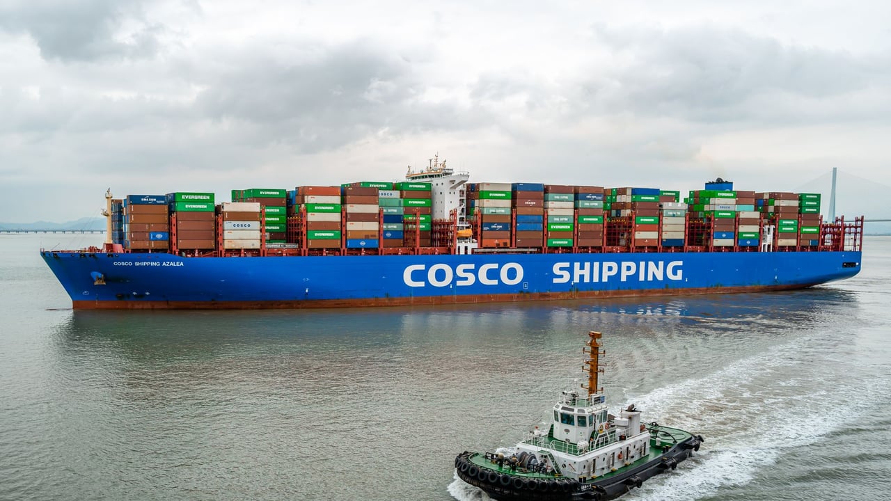 A large COSCO container ship navigates the waters of Ningbo Harbor, China.