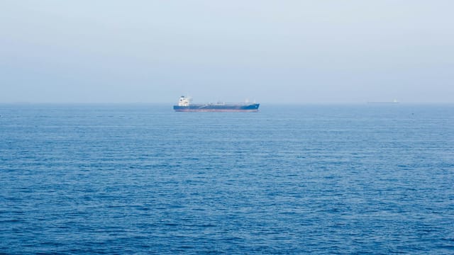 A large cargo ship sails on the tranquil ocean near Vũng Tàu, Vietnam, symbolizing global commerce.