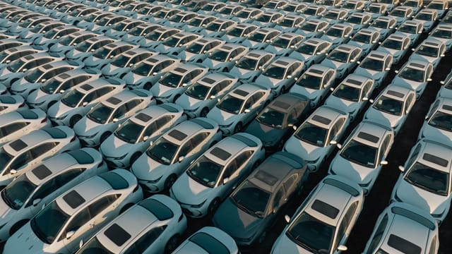 Overhead view of neatly arranged cars in a Libyan parking lot, captured at day.