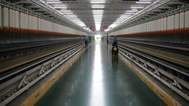 Spacious textile machinery hallway in an Indian industrial plant showing advanced equipment.