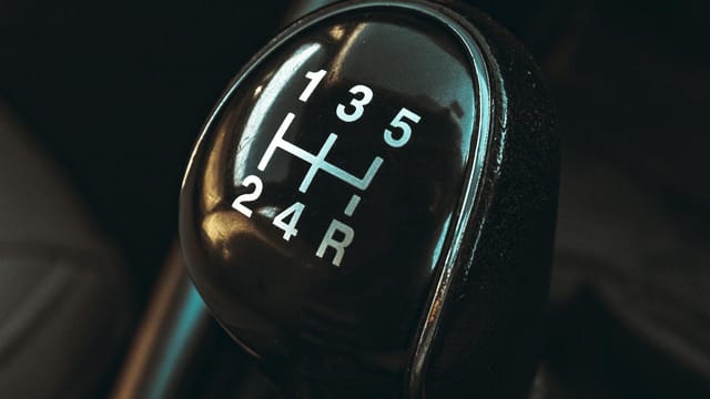 Detailed view of a car gearshift lever highlighting control and mechanics.