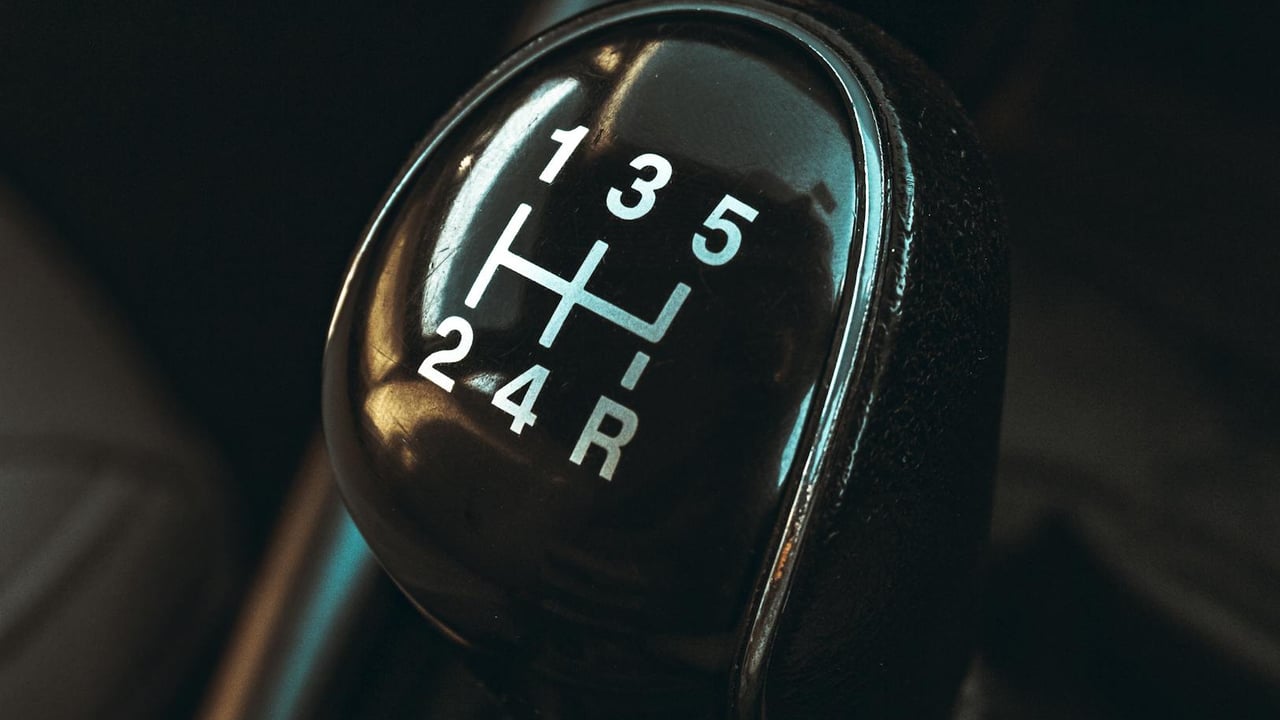 Detailed view of a car gearshift lever highlighting control and mechanics.