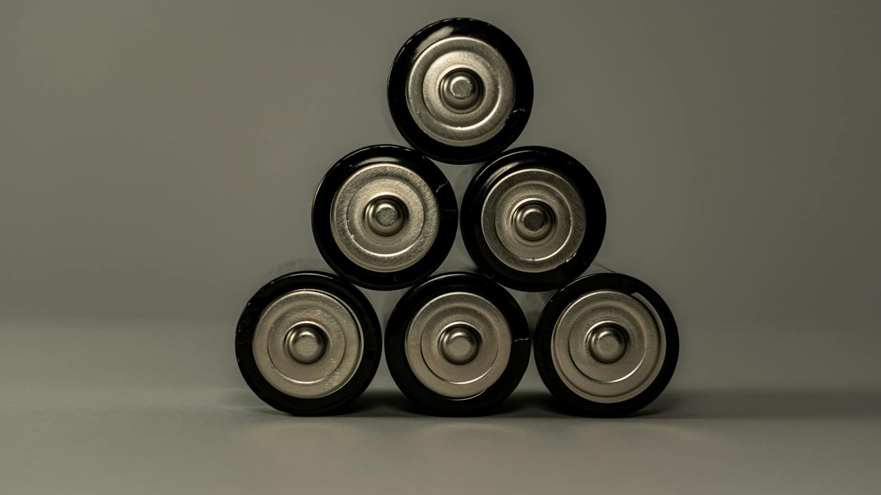 Metallic AA batteries stacked in a pyramid shape, symbolizing power and energy storage.