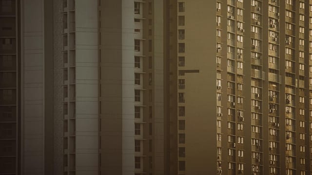 Close-up of high-rise buildings with geometric facades in warm evening light.