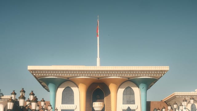 Explore Al Alam Palace, a historic landmark in Muscat, Oman, showcasing its vibrant Islamic architecture.